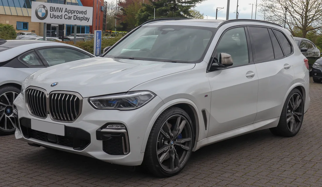 White BMW X5 SUV photographed from the front and side.